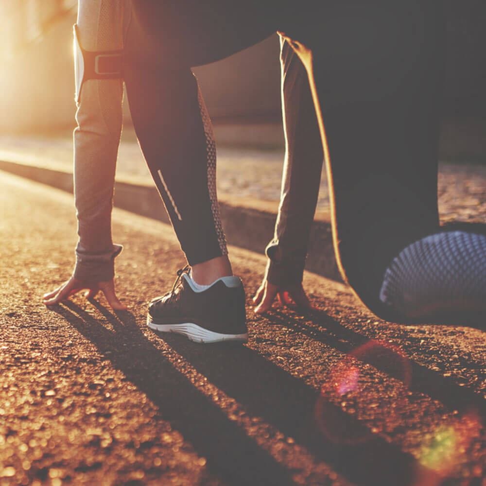 Person in running gear stretching, highlighting athlete eating disorder risks in NYC.