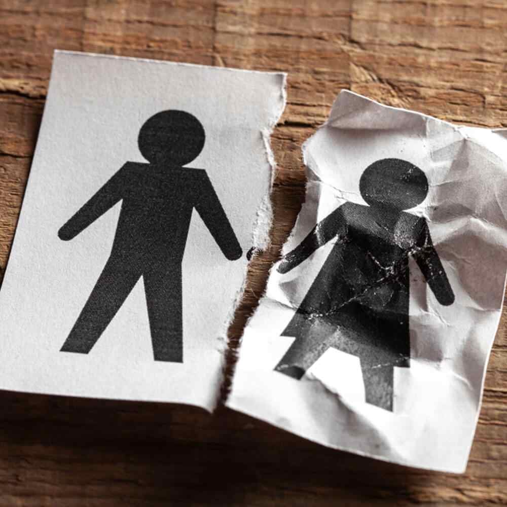 Two paper figures, one intact and one torn, representing life after a spouse’s death in NYC.