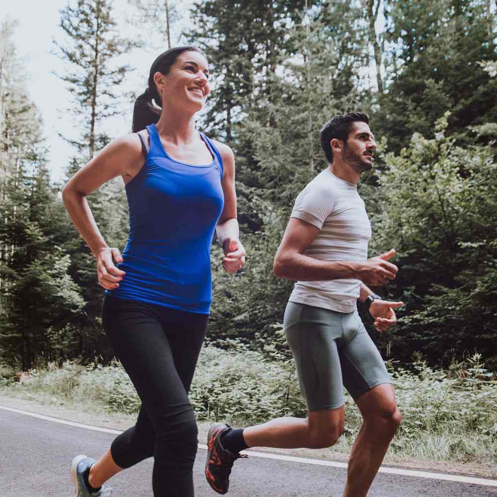 Two people jogging through a forest, setting healthy relationship boundaries in NYC.