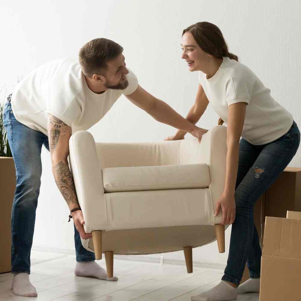 Two people lifting armchair with moving boxes, relationship renewal for the new year in NYC.