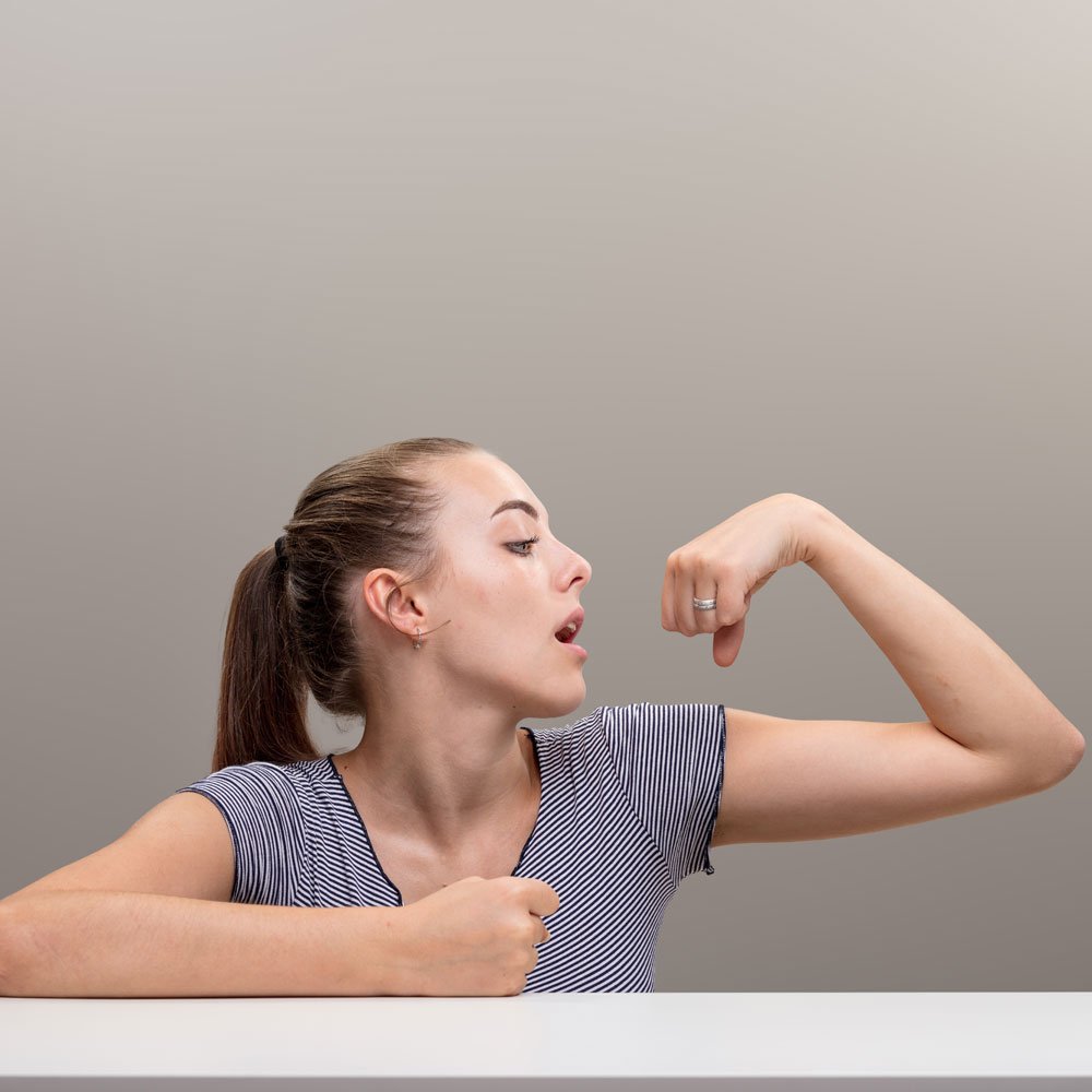 Woman flexing arm muscles, addressing validation-seeking behavior in NYC.
