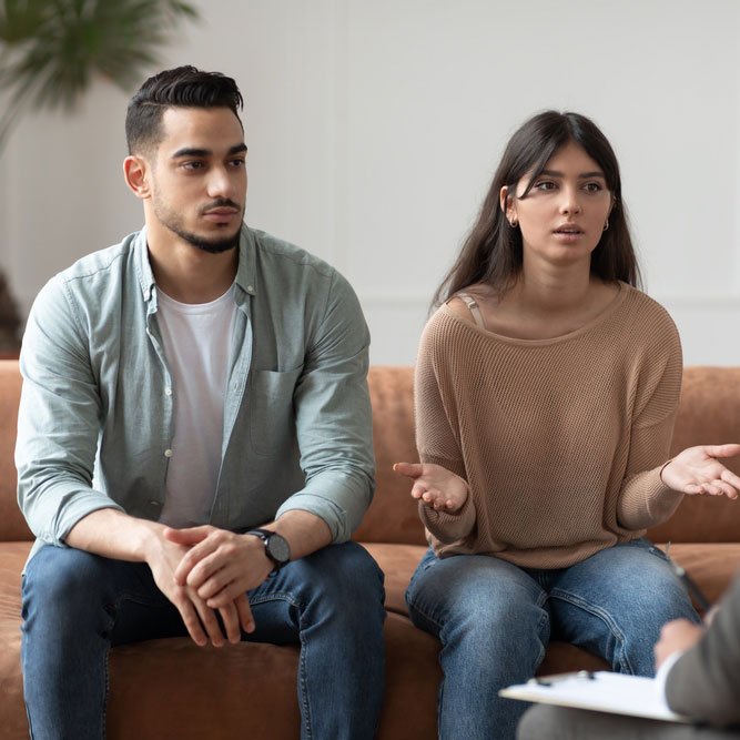 Serious young lady talking to psychologist counselor complaining on bad relationship with husband