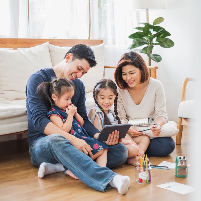 Happy Asian family using tablet watching movies, relaxing at home for lifestyle concept