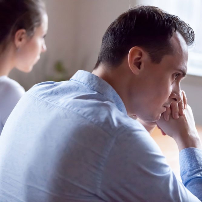 Spouses after quarrel sitting together at home thinking about relations and grievances.