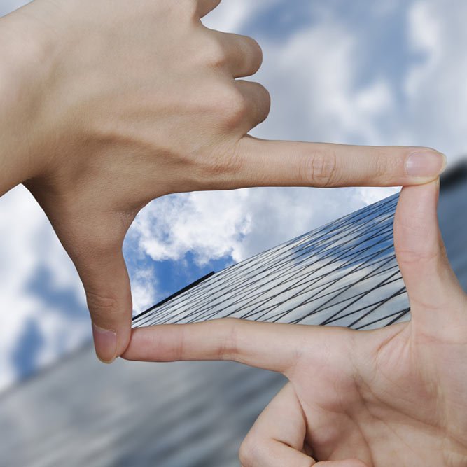 out of focus business building and fingers creating a square making the vision clear