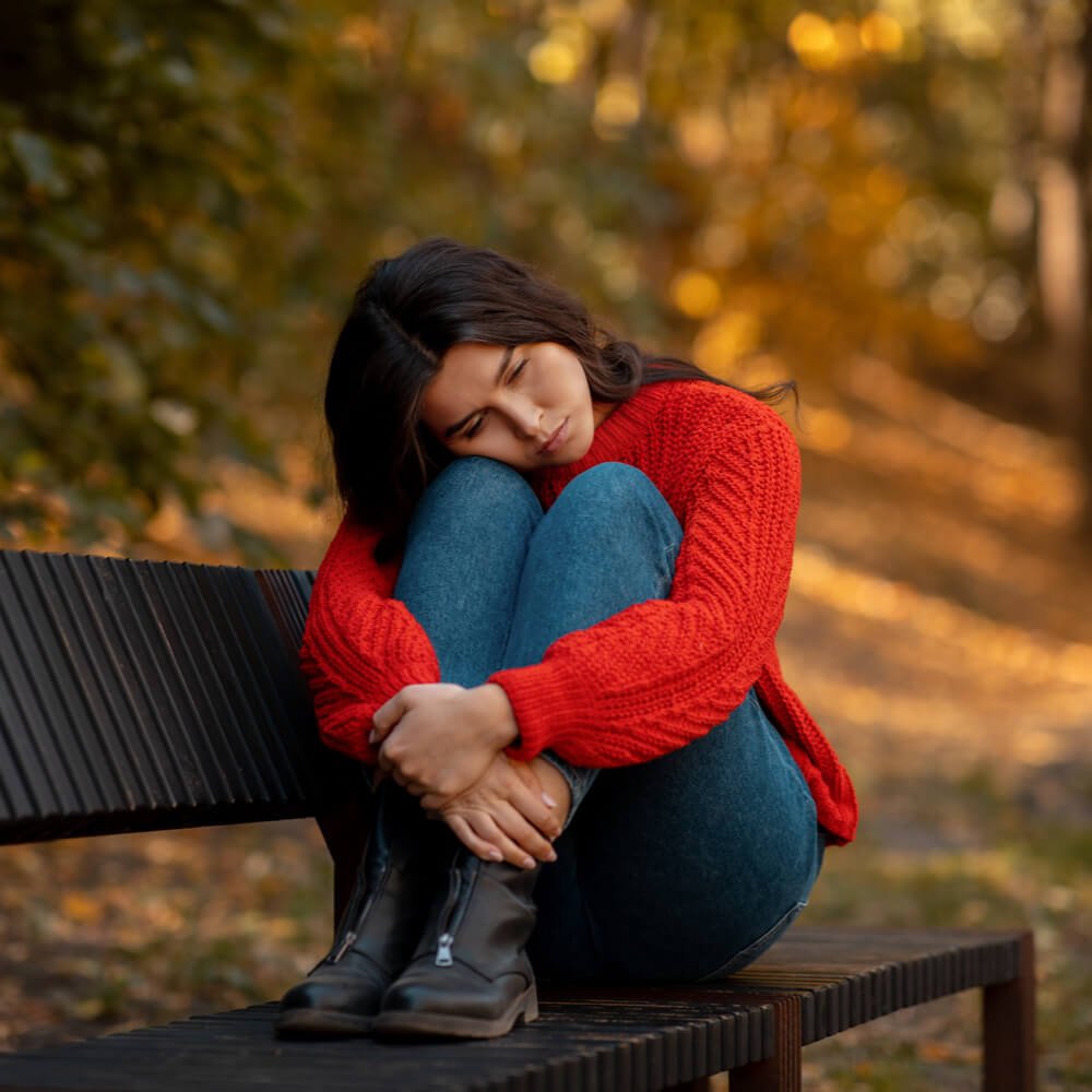 Person in a red sweater, coping with seasonal affective disorder in NYC.