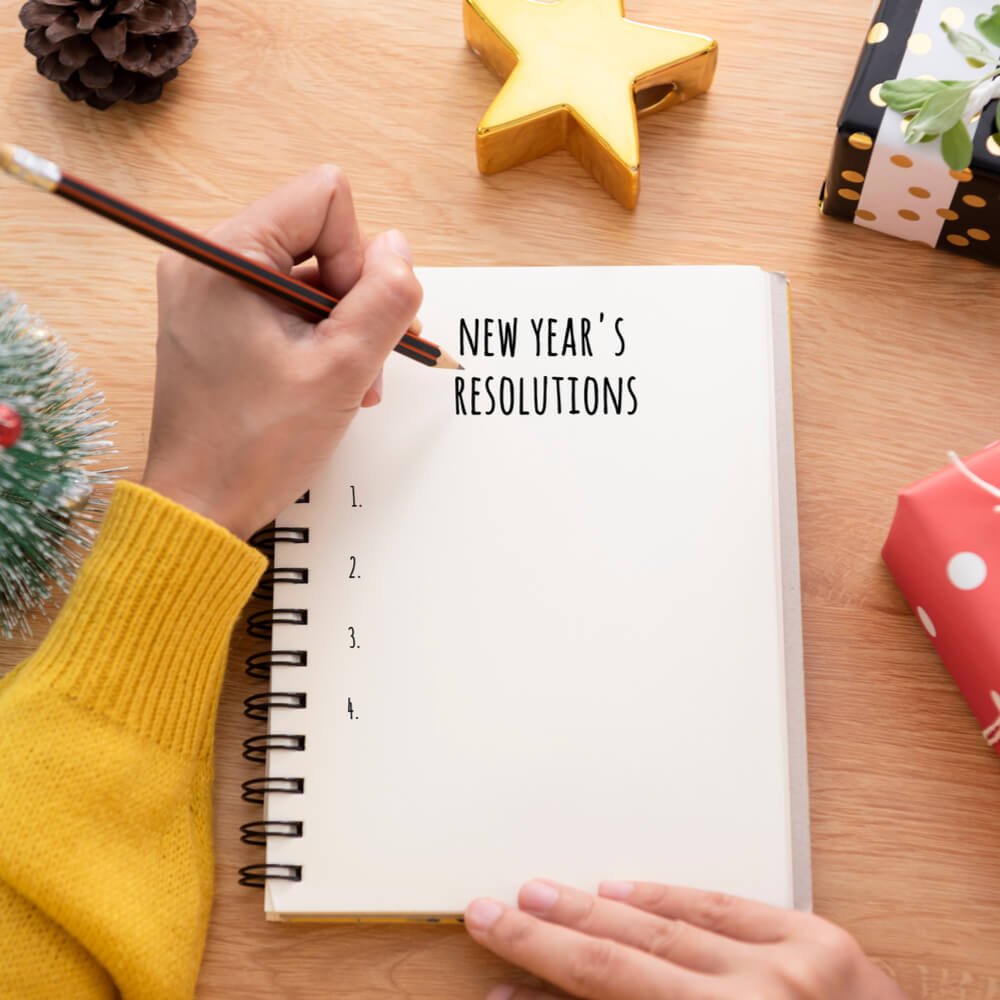 Person writing a New Year's Resolutions list, focusing on becoming a more authentic self in NYC.