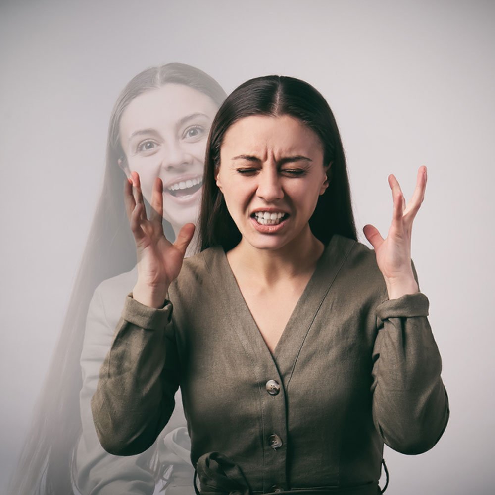 Person in a green blouse with hands up, exploring violence in bipolar disorder in NYC.