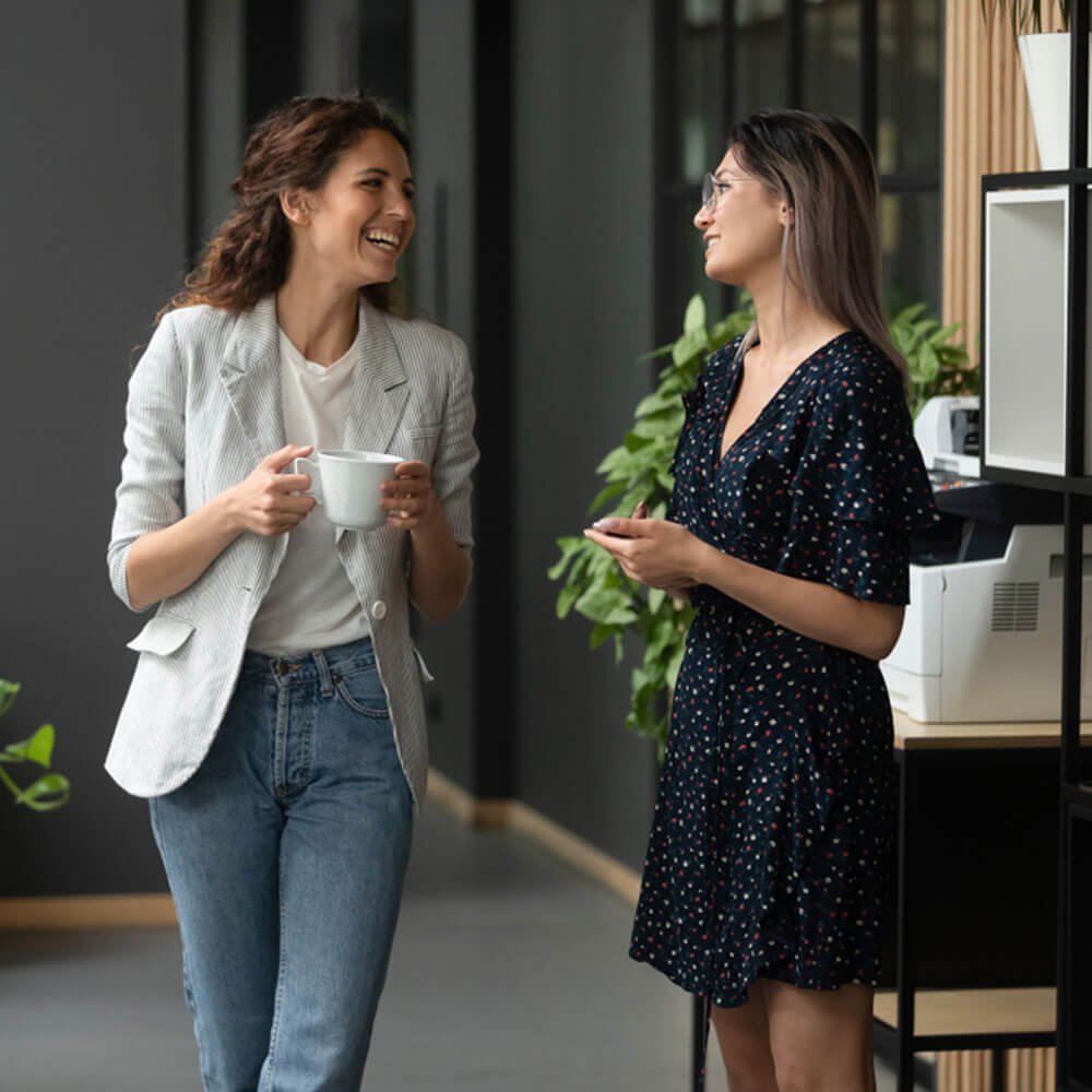 Two women in an office setting, discussing the importance of interpersonal communication in NYC.