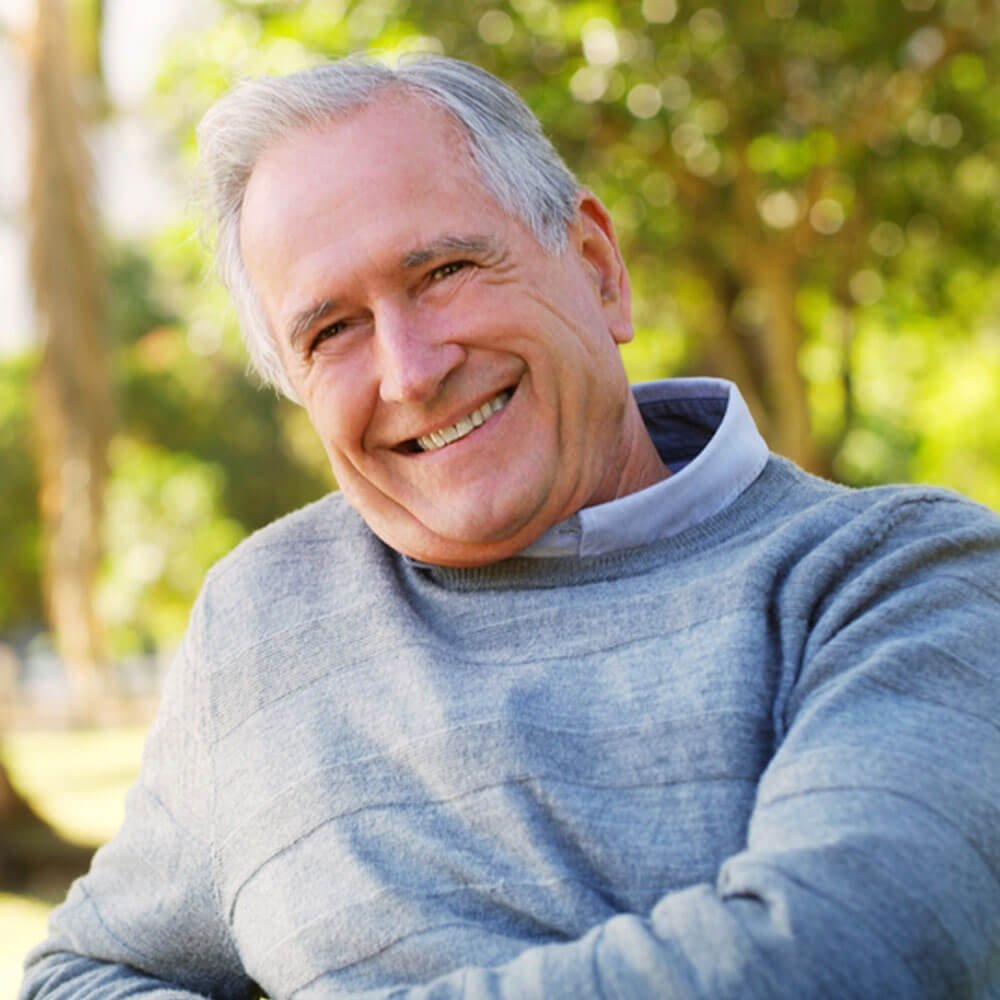 Elderly person in a blue sweater outdoors, exploring how to achieve ultimate happiness in NYC.