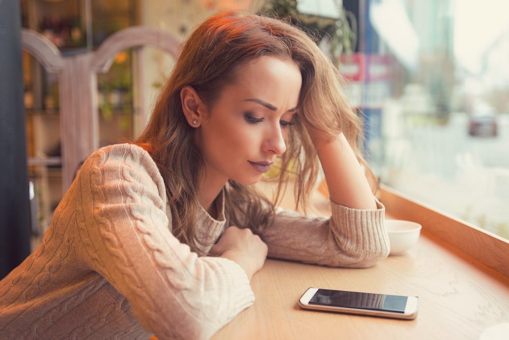 Woman Stressed Looking at Phone