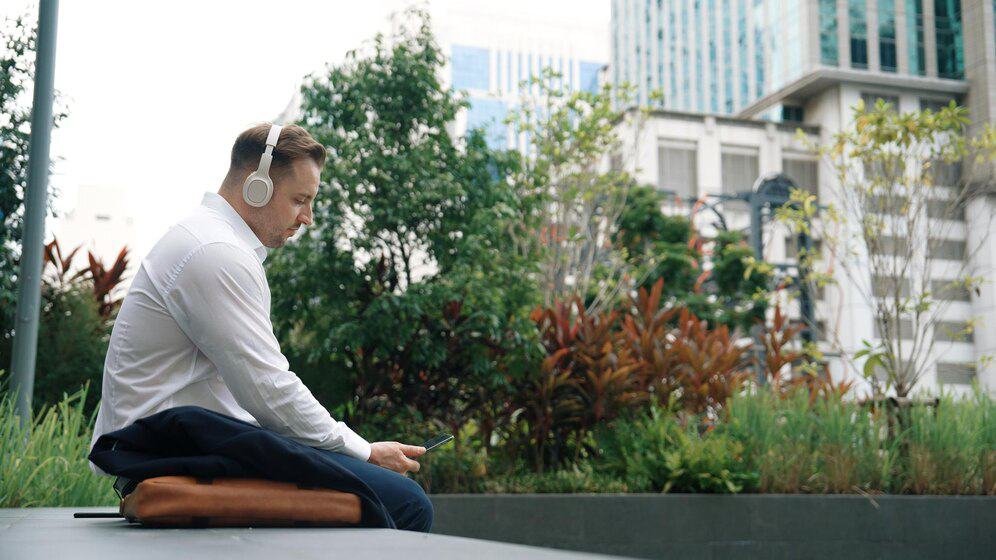 Businesspeople wear his headphone while take off suit and move to music Urbane
