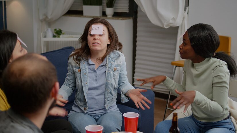 Multi ethnic friends drinking beer while playing guess who game using sticky notes