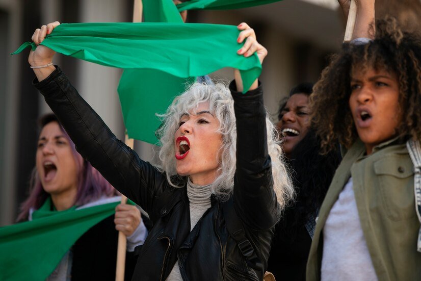 a group of people holding and waving a green flag