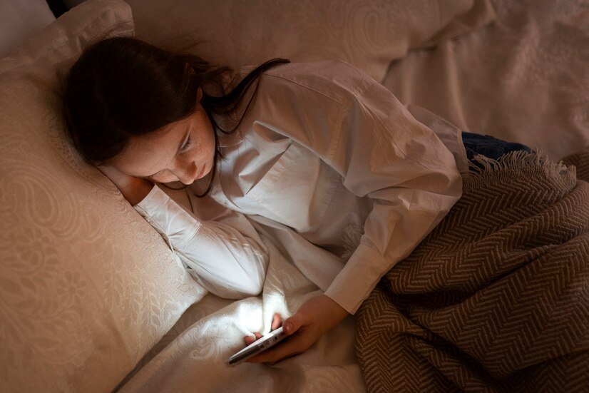 a woman holding her phone reading blogs on how to cope up from insomnia during period